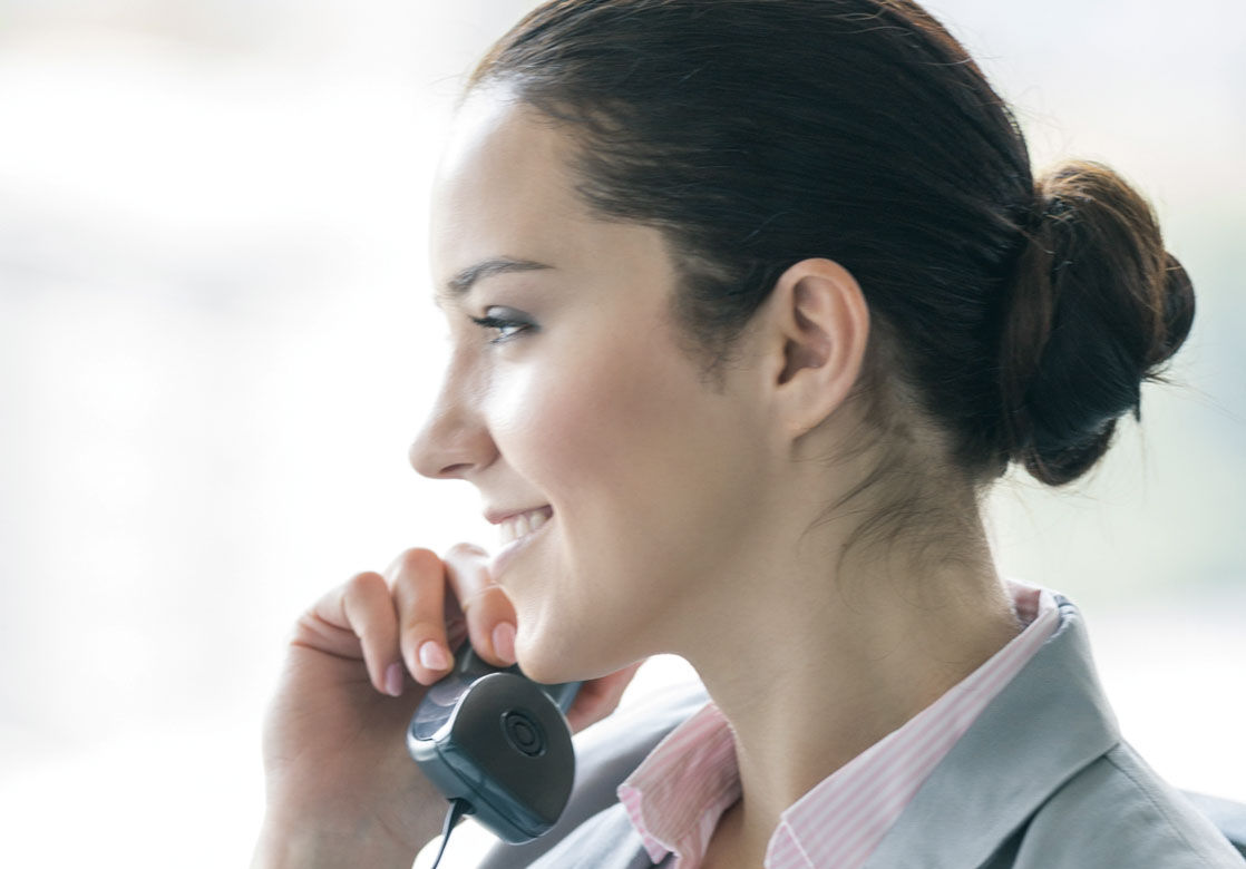 Frau mit einem Telefonhörer am Ohr