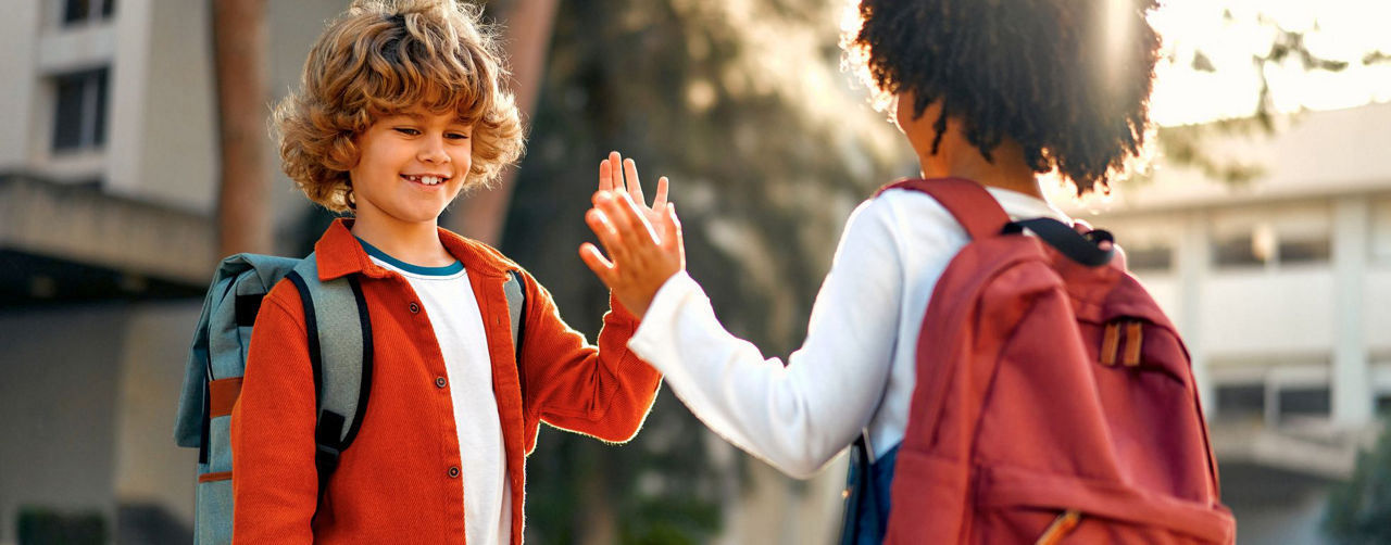 Zwei Grundschüler klatschen sich ab.