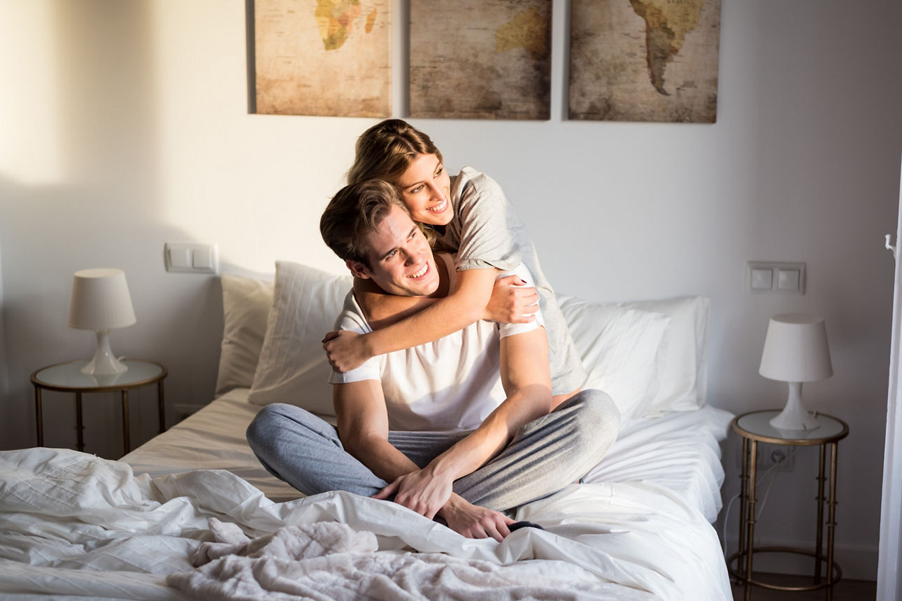 Ein junges Paar lachend auf einem Bett