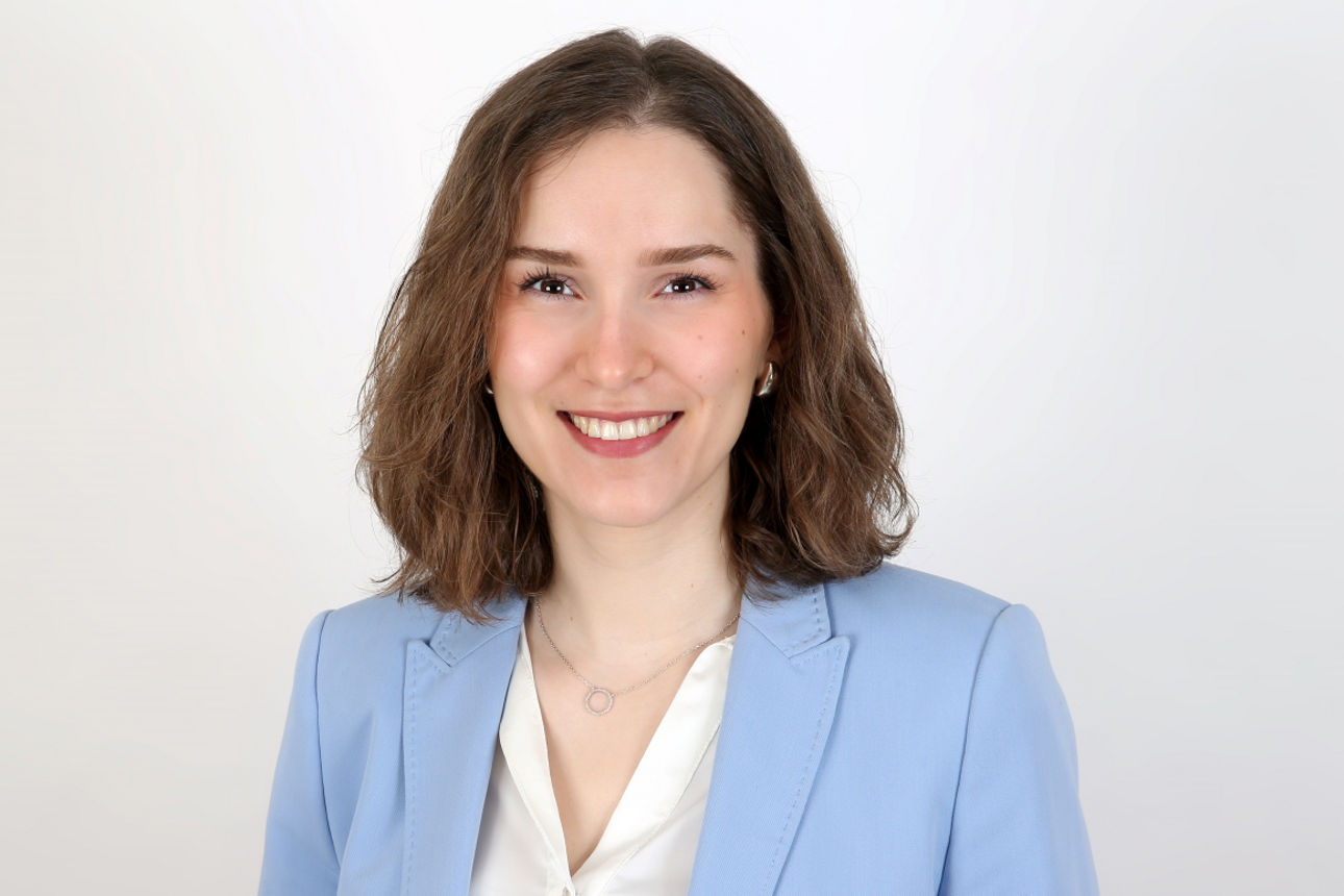 Eine lächelnde Frau schaut in die Kamera.