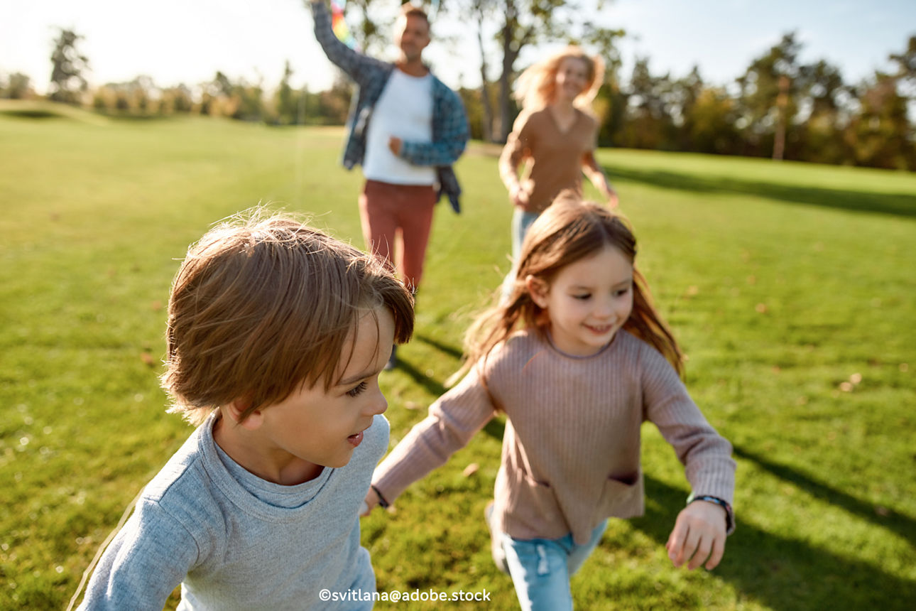 Zwei Kinder rennen auf einer Wiese