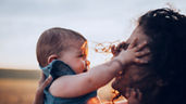 Mutter hält Baby im Sonnenschein