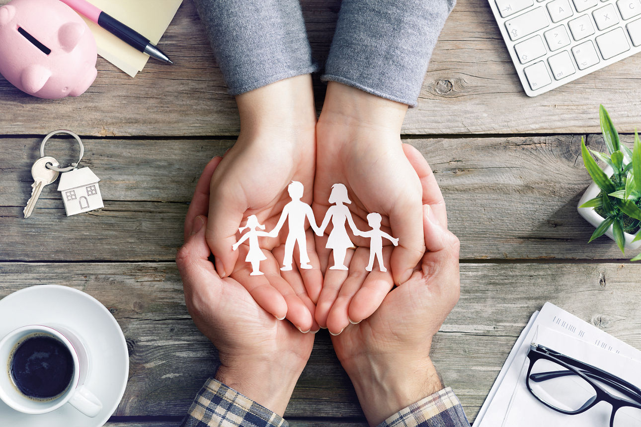 Darstellung Familie - vier Hände die eine Familie aus Papier halten