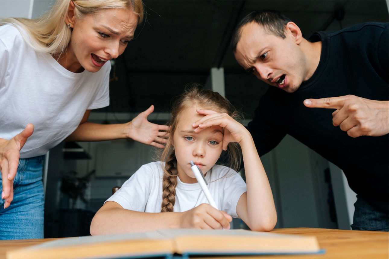 Trauriges Kind sitzt mit dem Stift in der Hand an den Hausaufgaben.