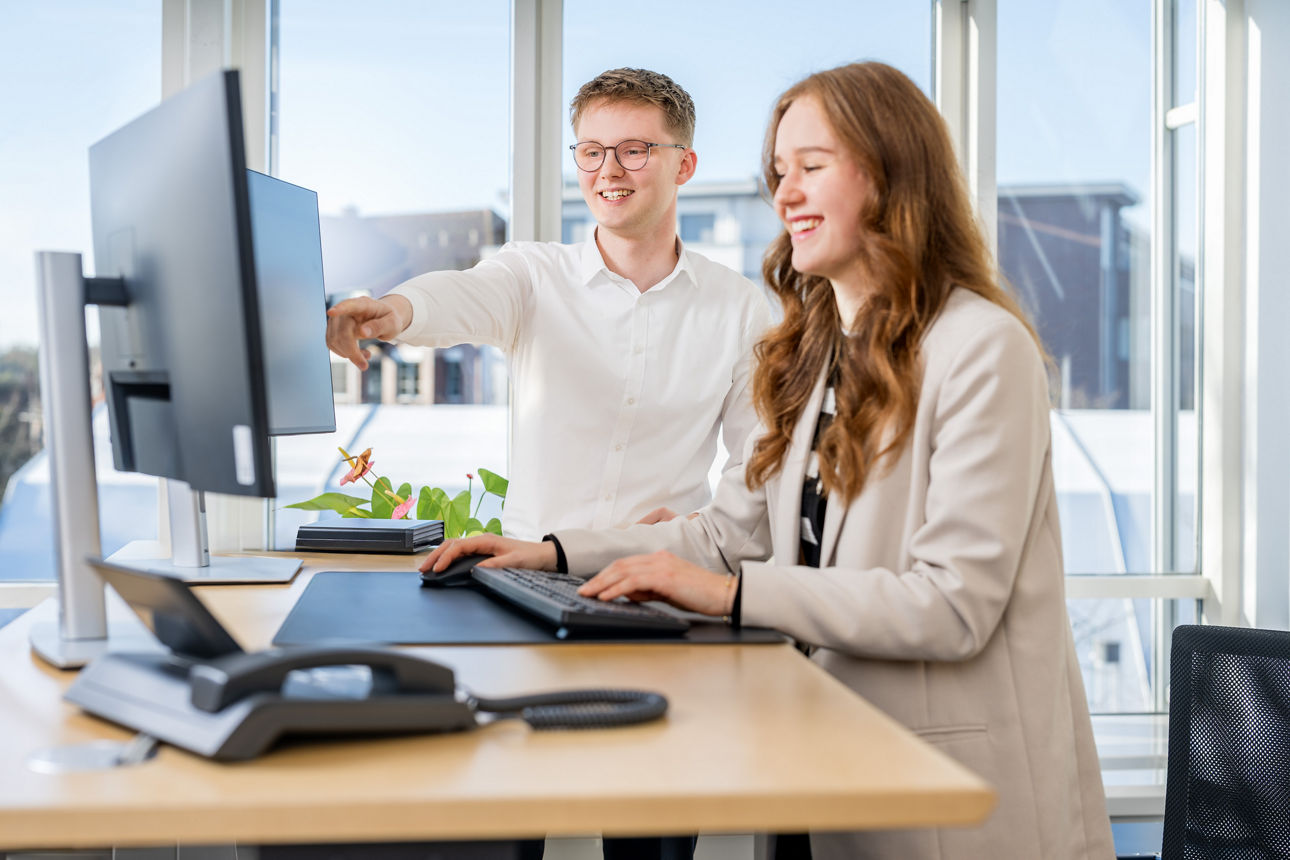 Ein Mann und eine Frau schauen auf einen Laptop