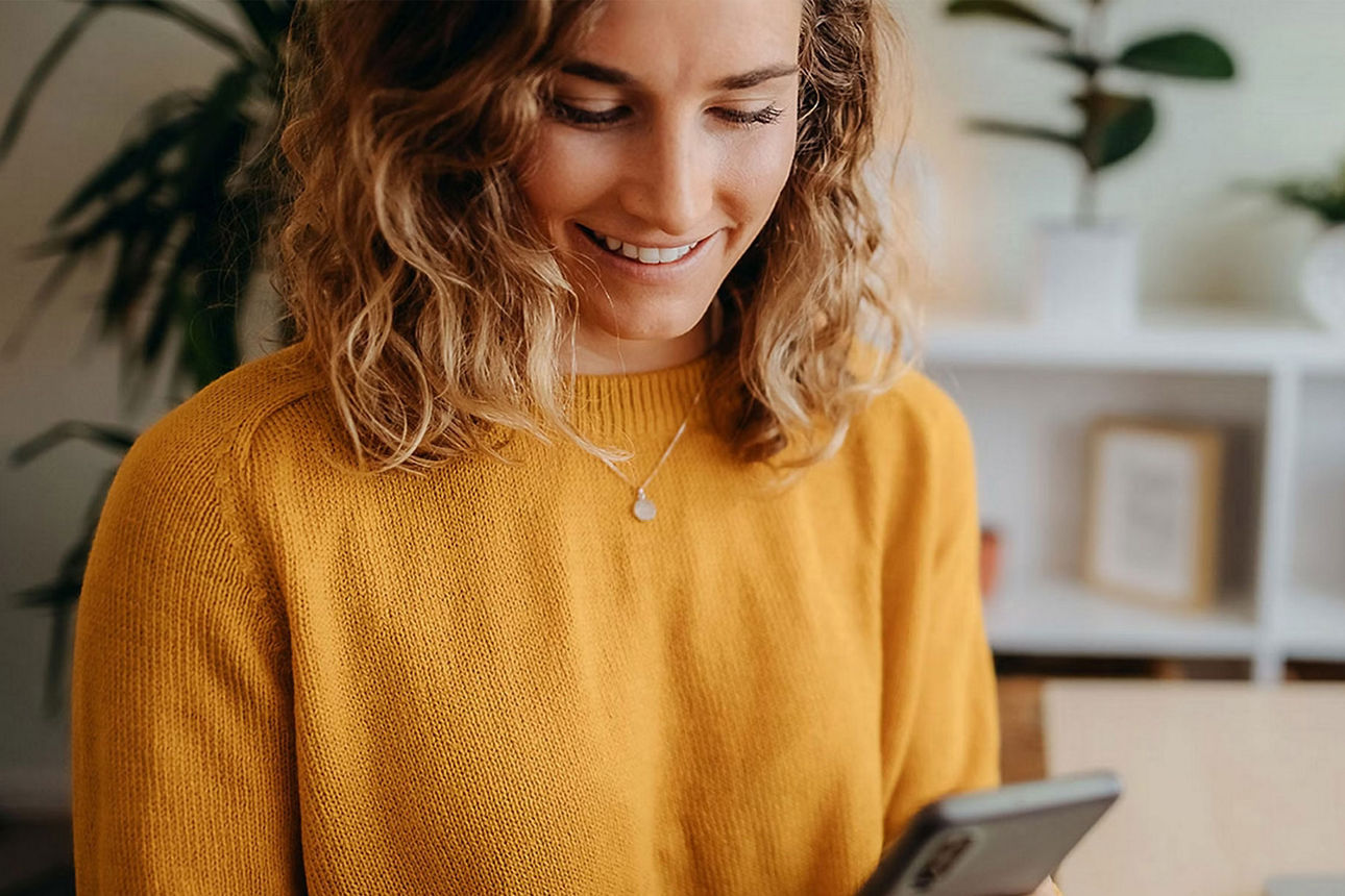 Junge Dame blickt auf ihr Smartphone