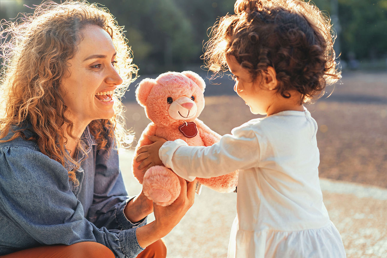 Eine Mutter schenkt ihrer Tochter einen Teddy