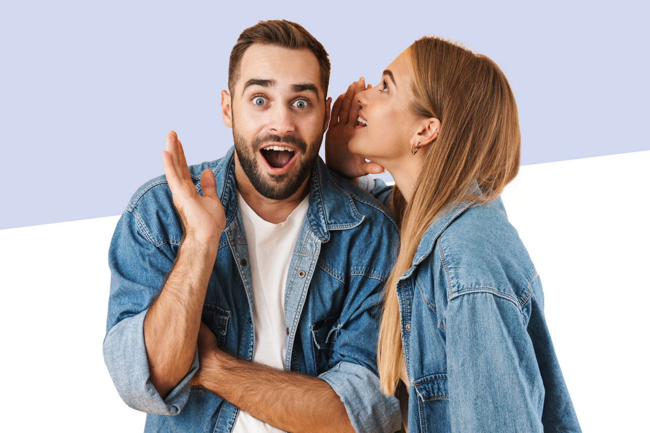 Eine Frau flüstert einem Mann etwas ins Ohr