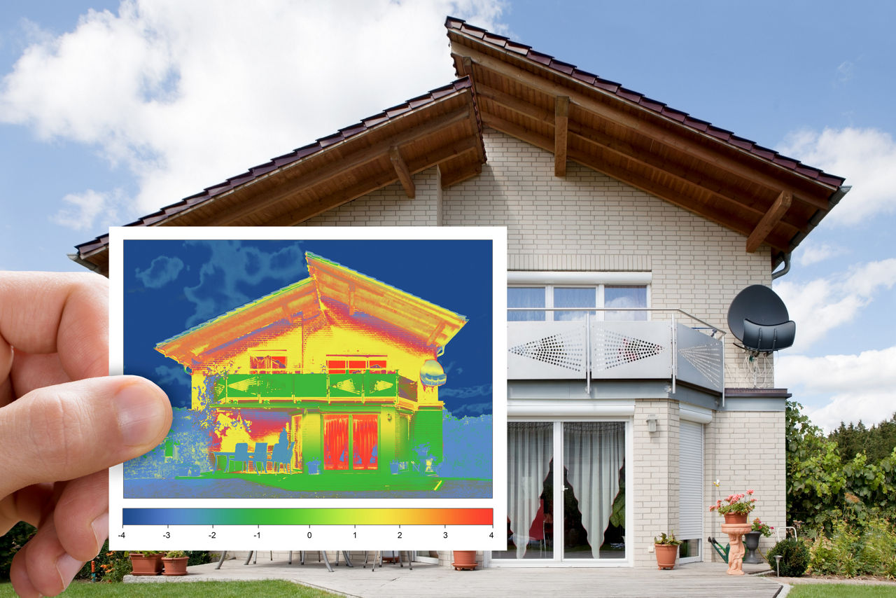 Haus mit Energieausweis im Vordergrund.