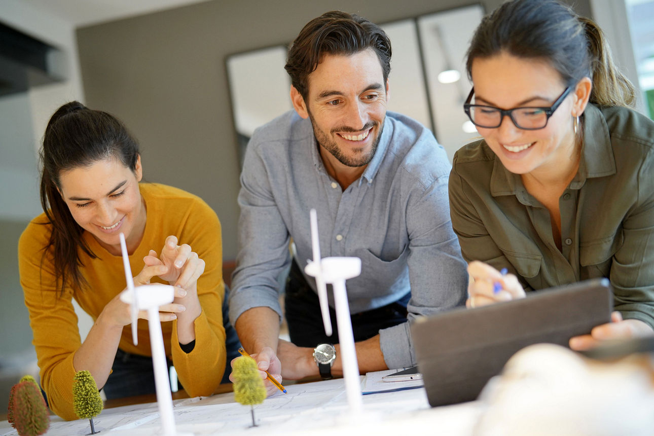 Drei Personen planen gemeinsam an einem Tisch.