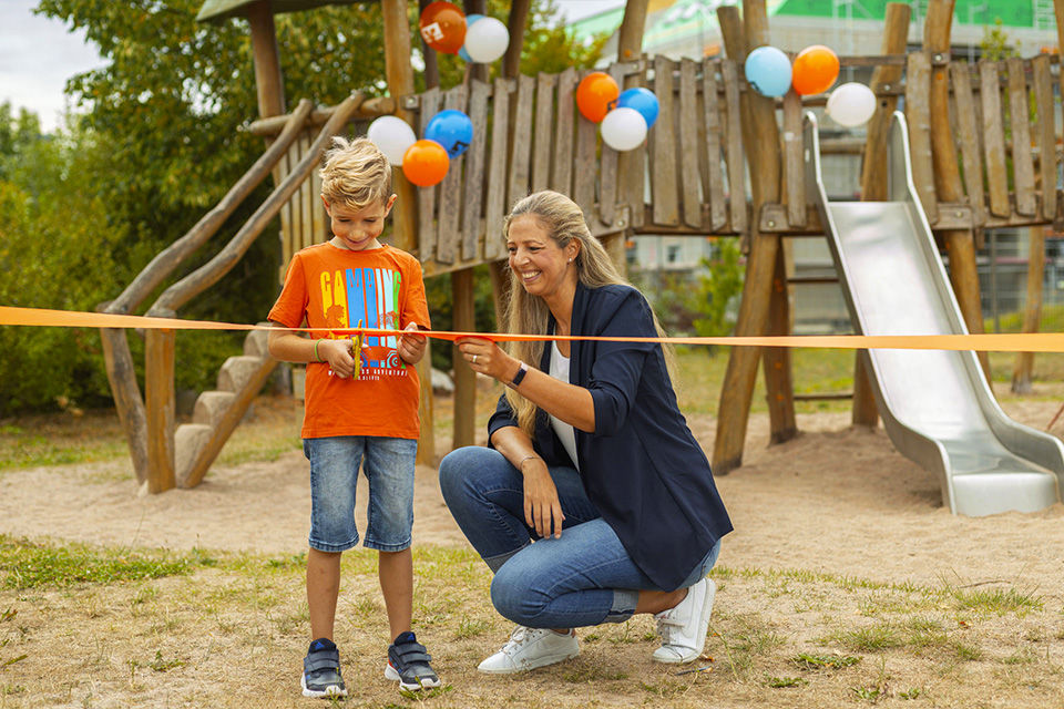 Ein Junge und eine Frau auf einem Spielplatz