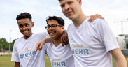 3 Jungen in weißen T-Shirts posieren zusammen für ein Bild
