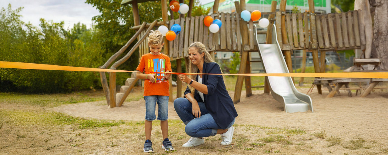 Ein Junge und eine Frau auf einem Spielplatz