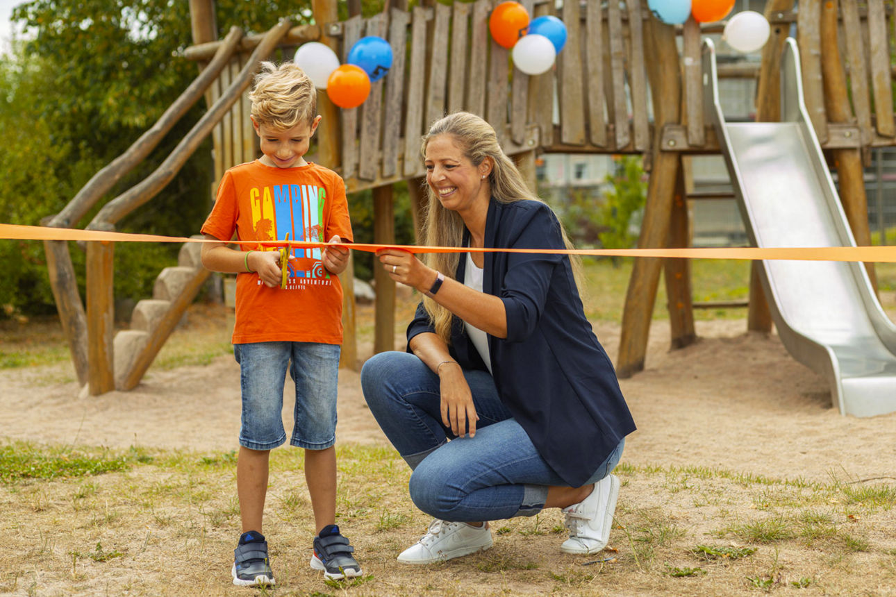 Ein Junge und eine Frau auf einem Spielplatz