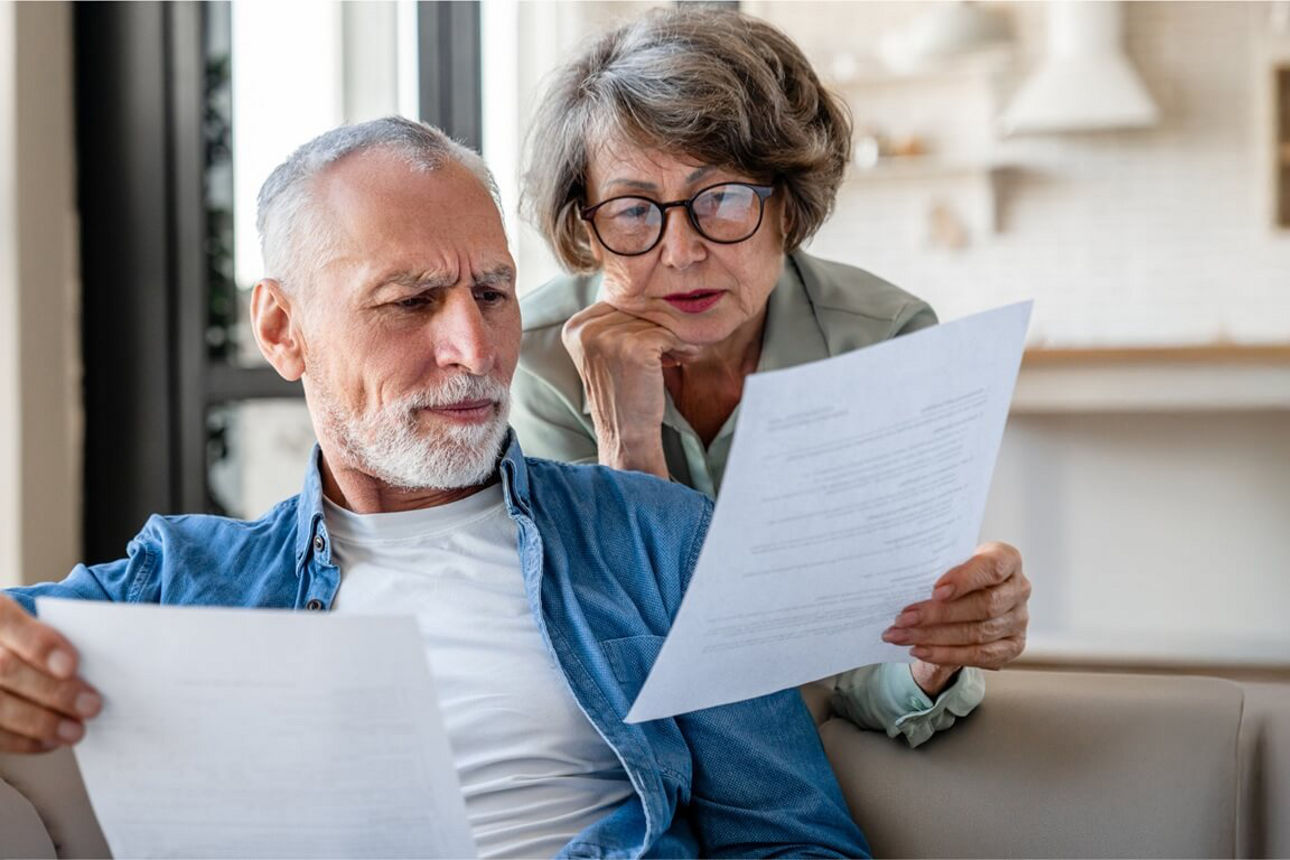 Älteres Ehepaar schaut zusammen auf Papier