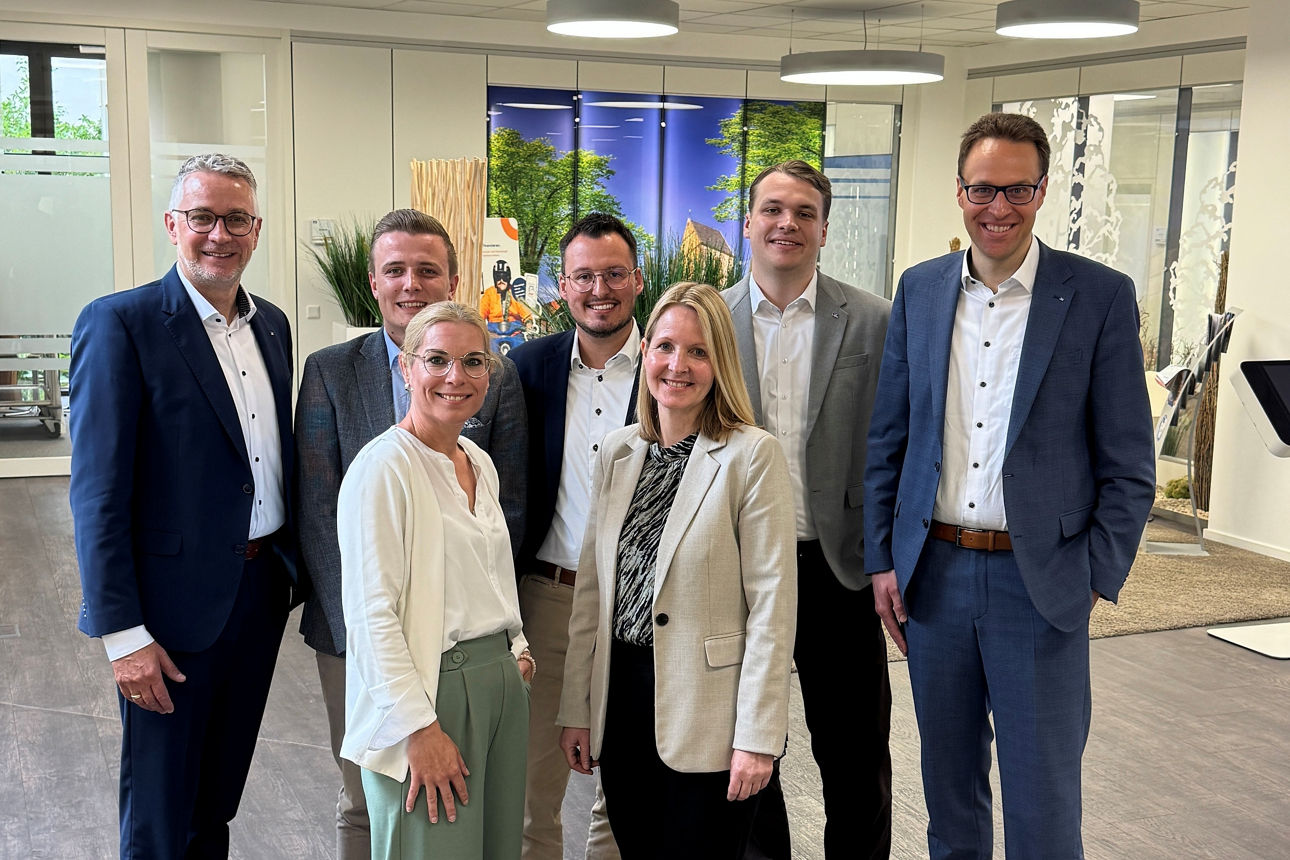 Eine Gruppe von Menschen in den Geschäftsräumen der Bank. 