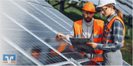Zwei Personen mit Schutzhelmen und Warnwesten inspizieren Solarpanels und betrachten eine Bauzeichnung.