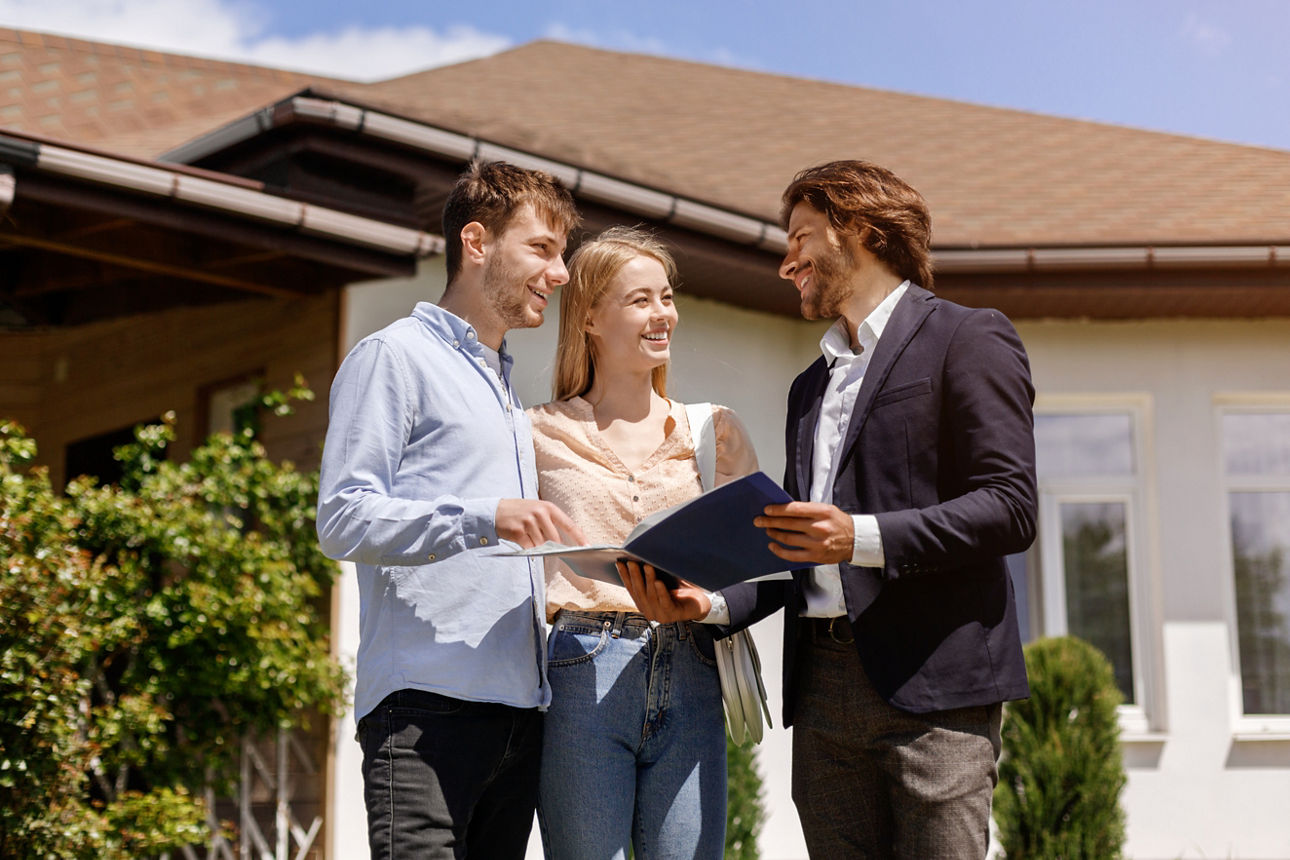 Real estate agent showing home rental or purchase contract to his customers in house backyard