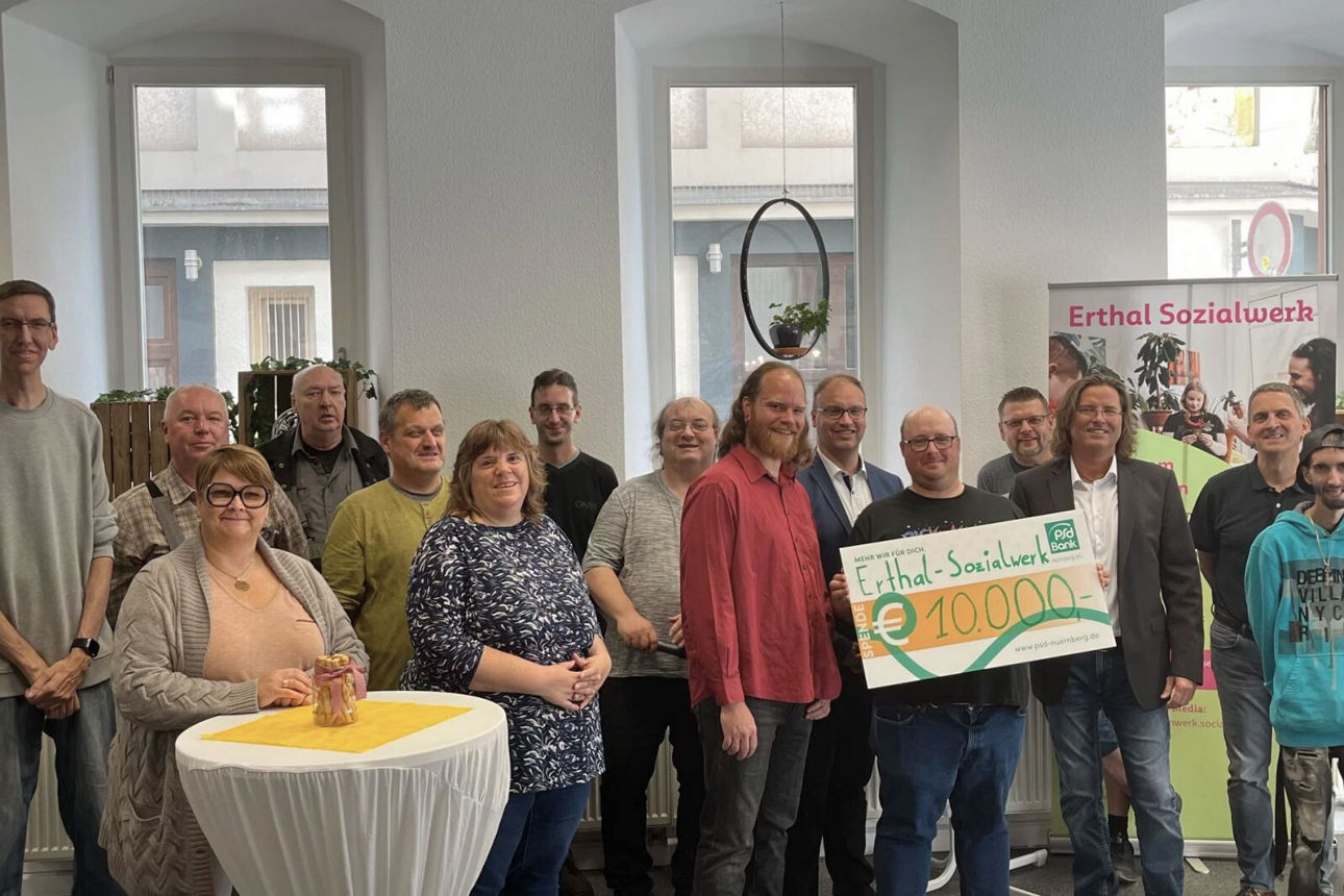 Ein Kollege der PSD Bank Nürnberg übergibt einen Spendencheck beim Hospizlauf Bamberg