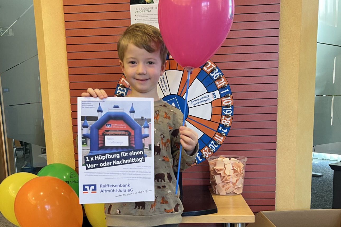 Kind mit Lutfballon hält Urkunde hoch