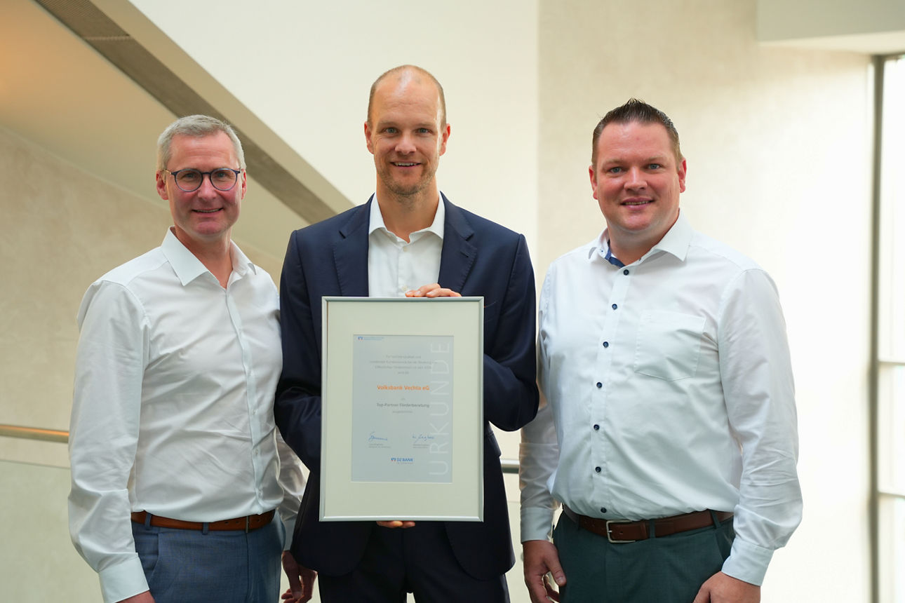 Drei Männer der Bank mit einer Urkunde in der Hand