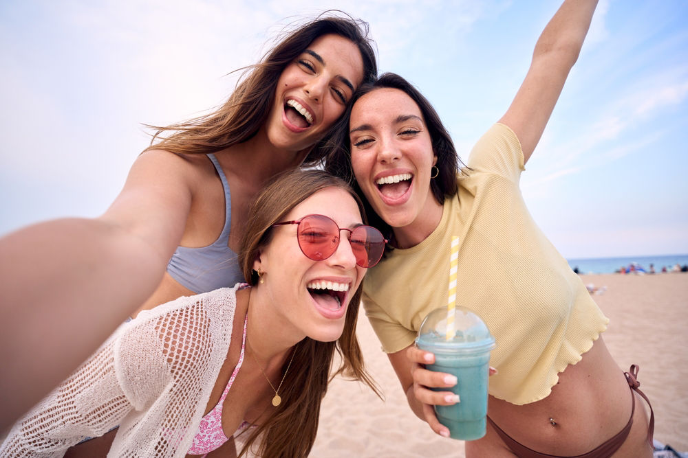 Eine Gruppe von Freundinnen posen am Strand für ein Foto