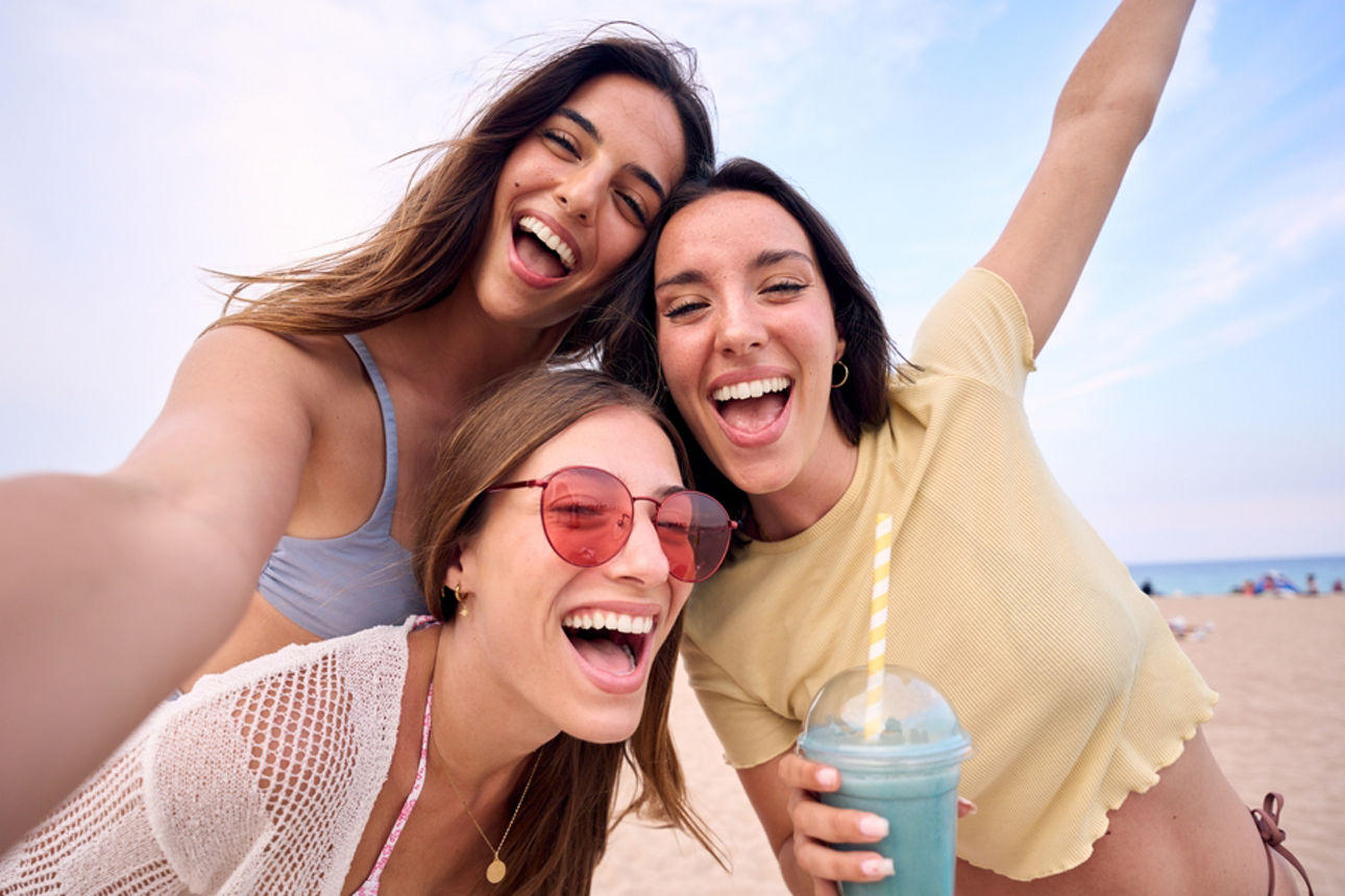 Eine Gruppe von Freundinnen posen am Strand für ein Foto