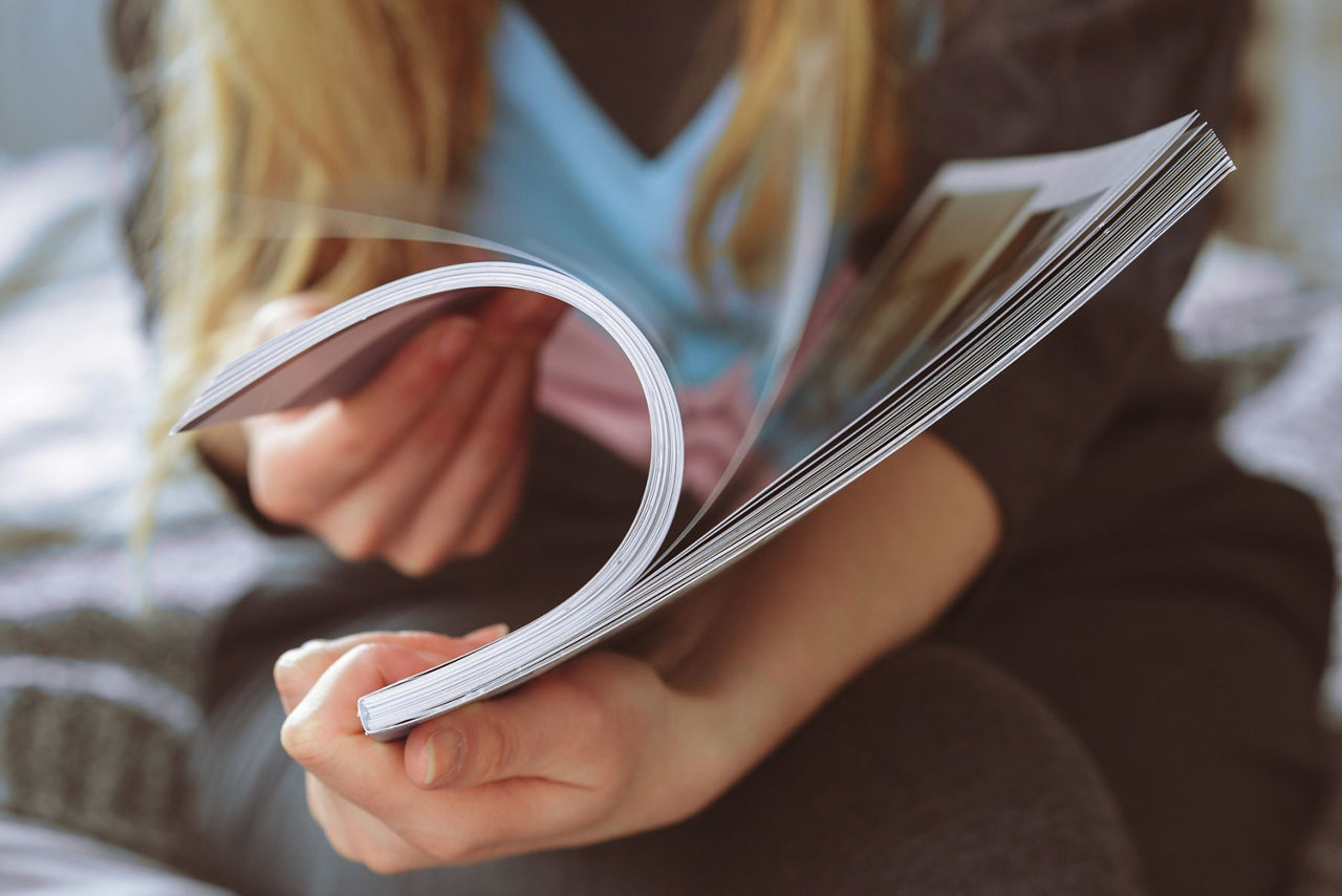 Frau blättert durch ein Magazin