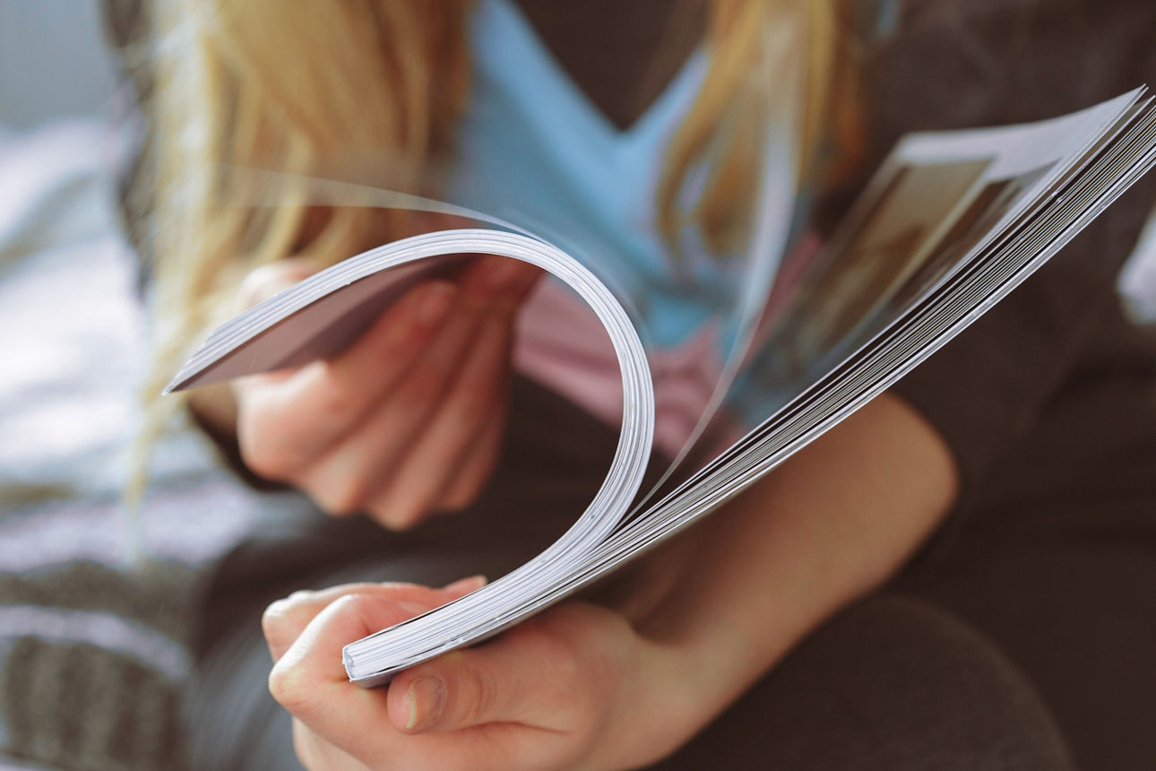 Frau blättert durch ein Magazin