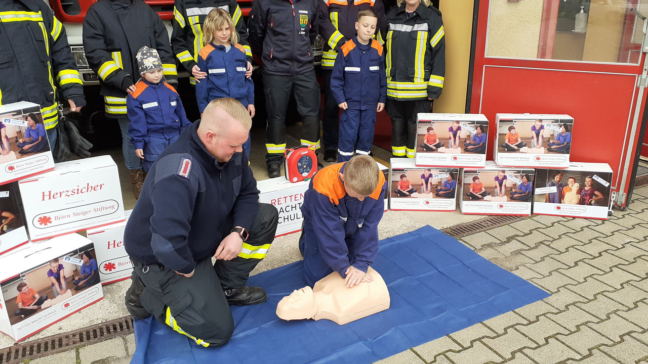 Feuerwehrleute zeigen Wiederbelebung an einem Reanimationsdummy