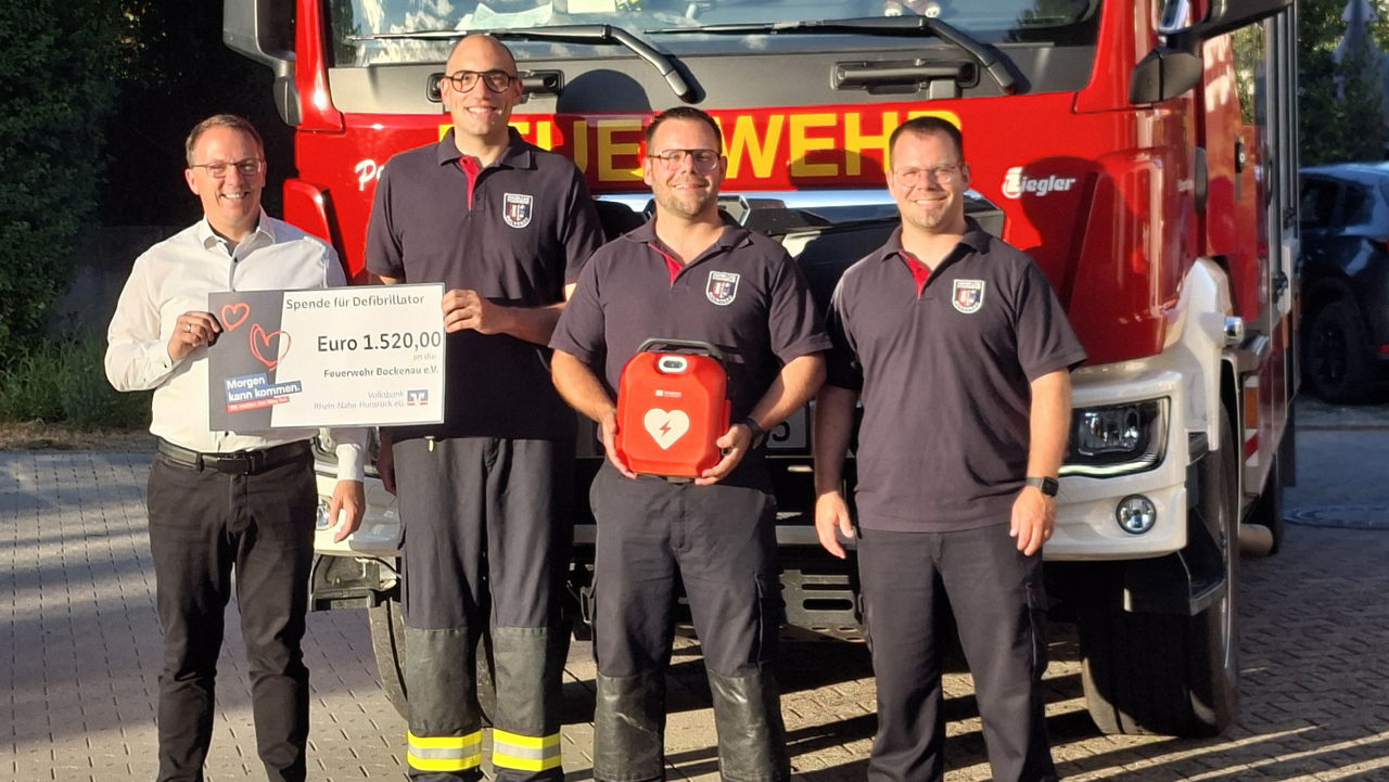4 Personen vor einem Feuerwehrfahrzeug