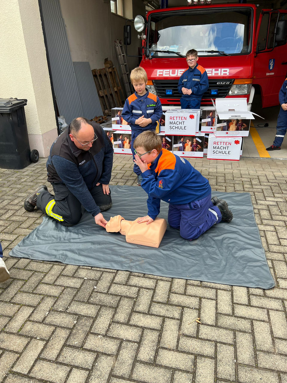 Feuerwehrleute zeigen Wiederbelebung an einem Reanimationsdummy