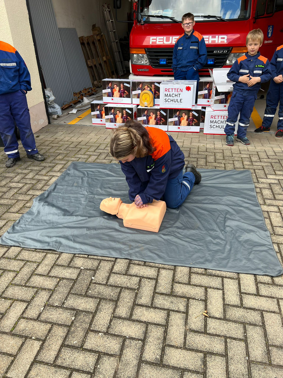 Feuerwehrleute zeigen Wiederbelebung an einem Reanimationsdummy
