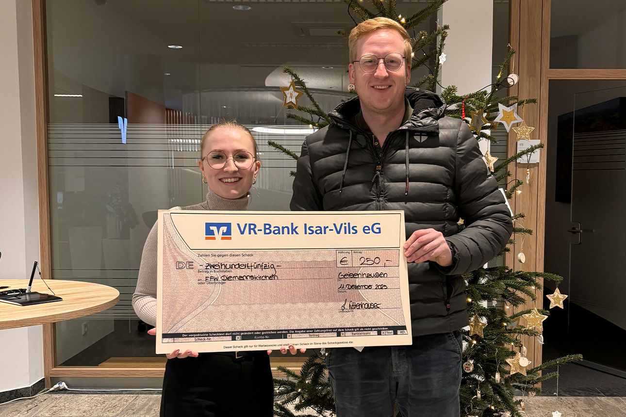 Eine Frau und ein Mann lächeln in die Kamera. Sie halten einen Riesenspendenscheck in der Hand.