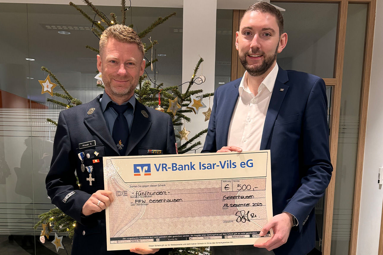 Zwei Männer lächeln in die Kamera. Sie halten einen Riesenspendenscheck in der Hand.