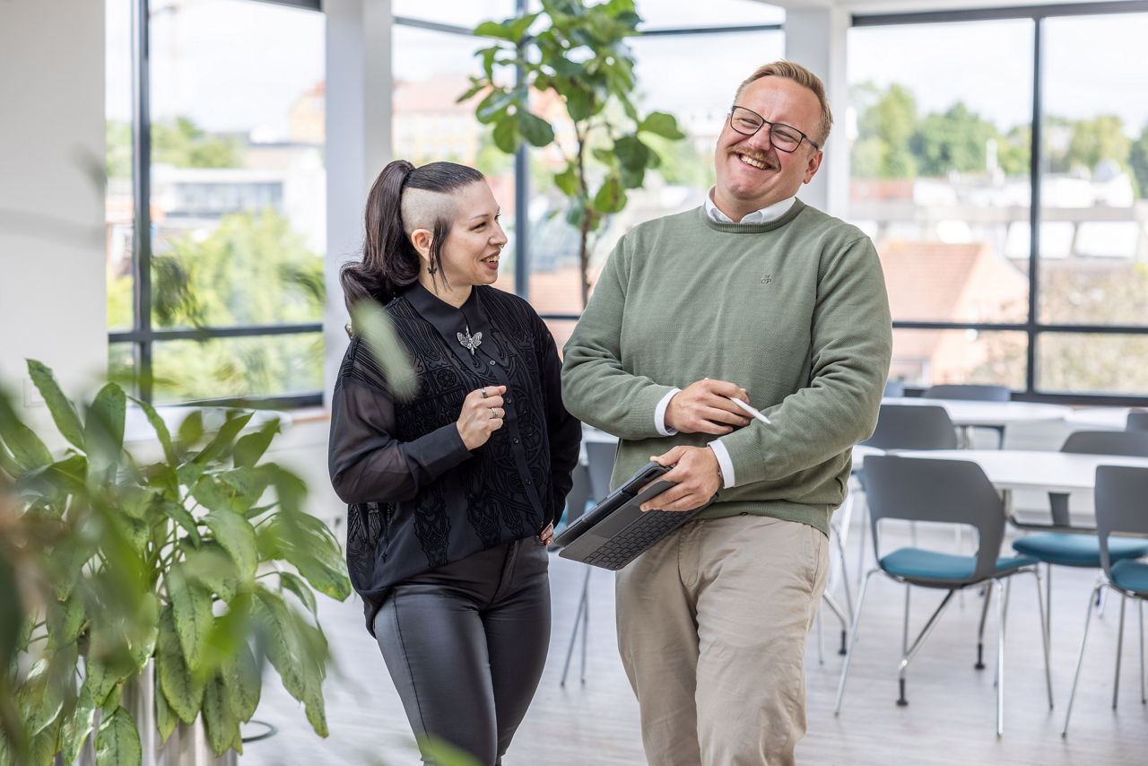 Eine Frau und ein Mann stehen lachend nebeneinander
