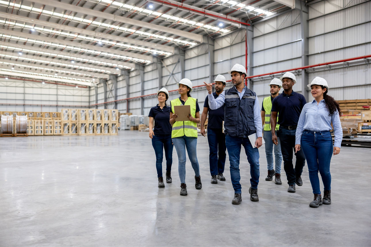 Produktionsleiter zeigt Besuchern Lagerhalle