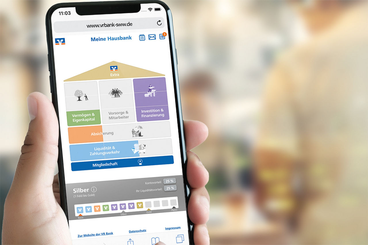 Smartphone zeigt Website einer Bank mit Kategorien wie Vermögen, Finanzierung, Absicherung und Mitgliedschaft.