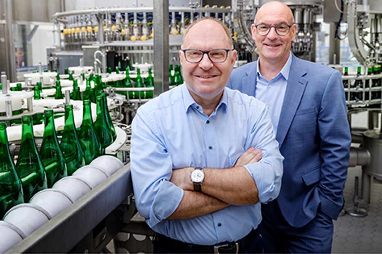 Berater und Kunde vor einer Flaschenanlage