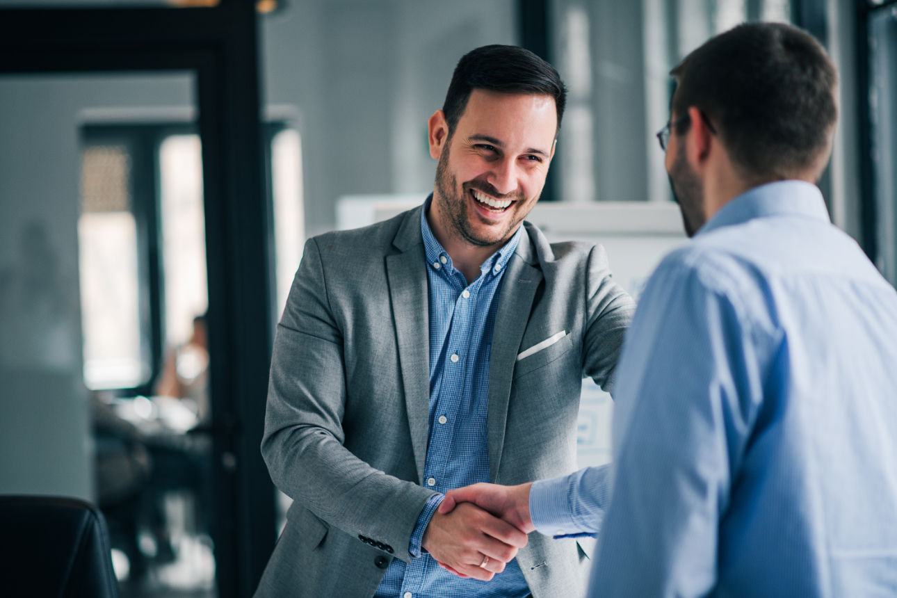 Mann schüttel lächelndem Mann die Hand