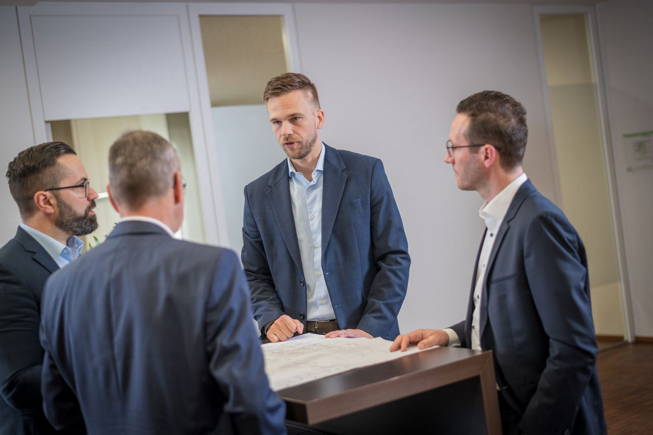 Geschäftsführer und junger Mitarbeiter in einer Fabrikhalle