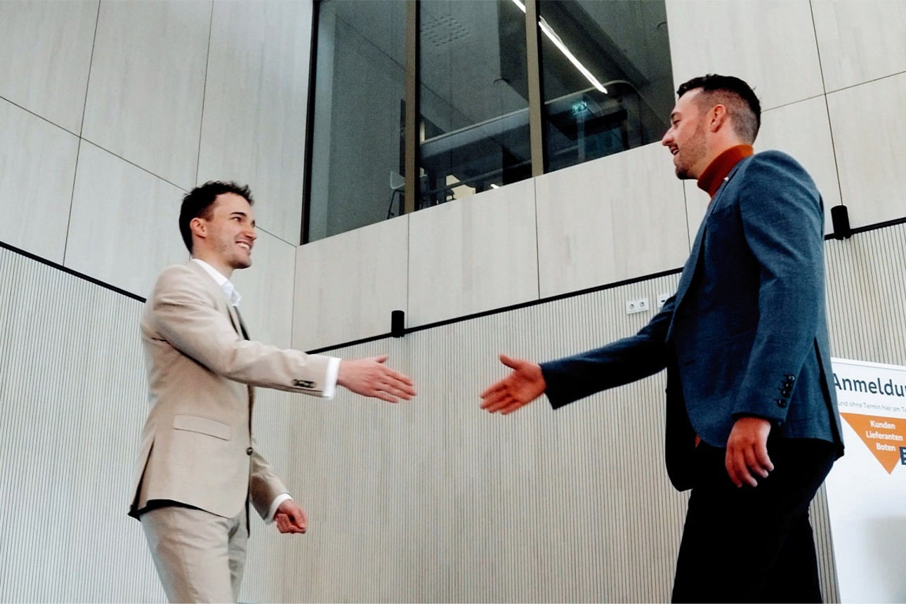 VR-Bank Memmingen Mitarbeiter schüttelt Firmenkunde die Hand