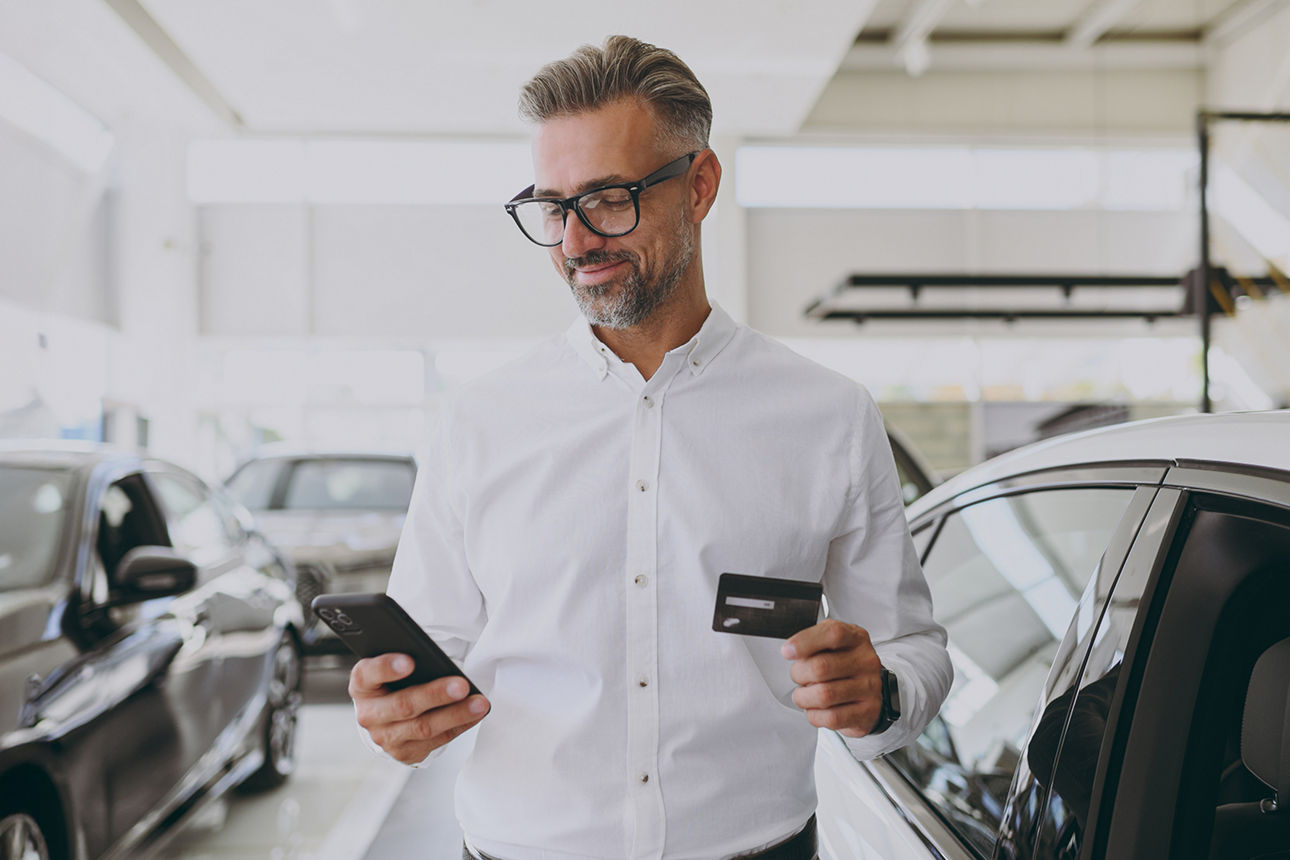 Ein Geschäftsmann bezahlt mit Firmenkarte einen Mietwagen.