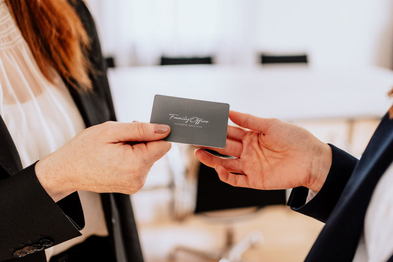 Überreichung einer Visitenkarte mit Family Office Logo