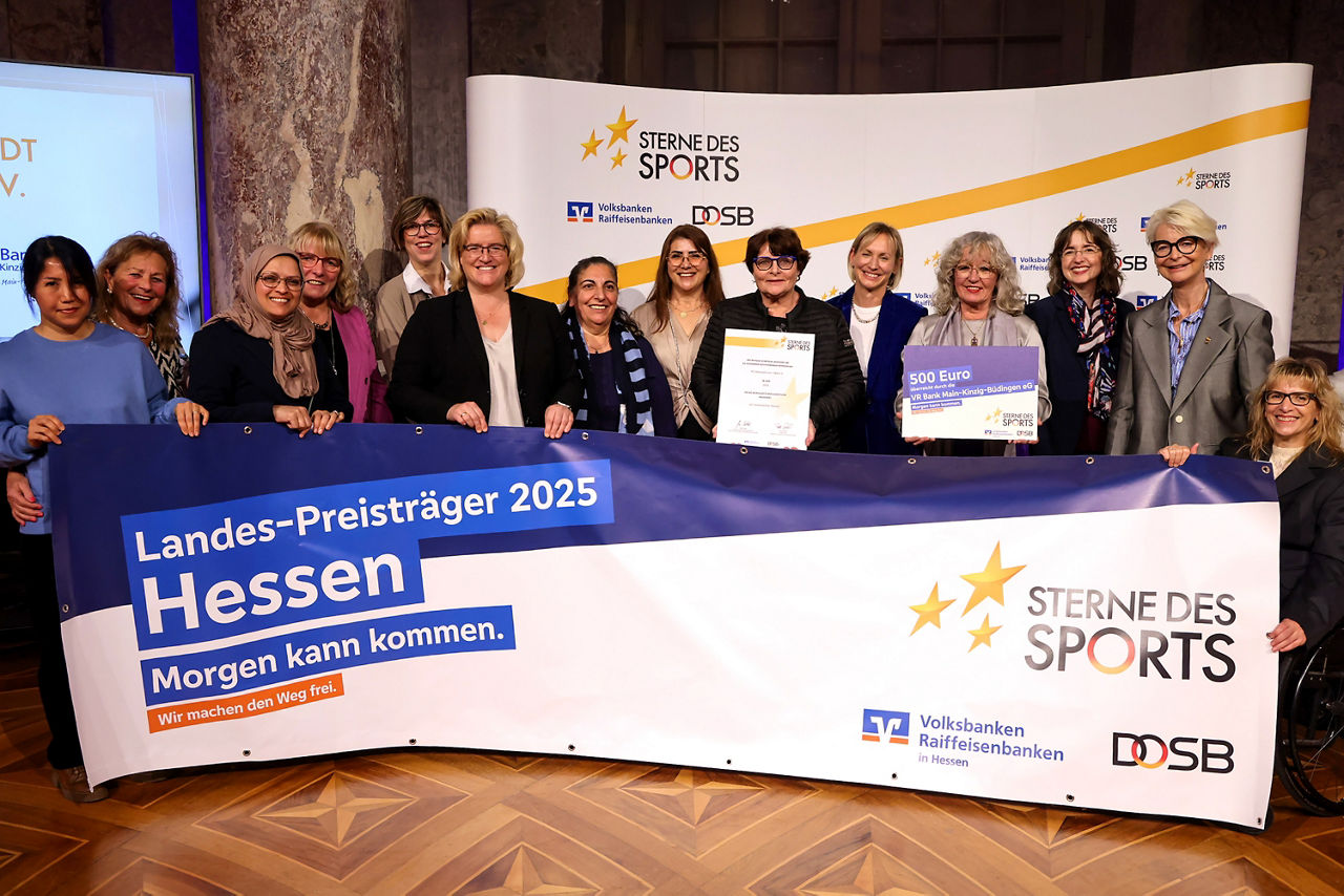 Gruppe von vierzehn Frauen hält Banner „Sterne des Sports – Landes-Preisträger 2025 Hessen“ bei einer Preisverleihung hoch.