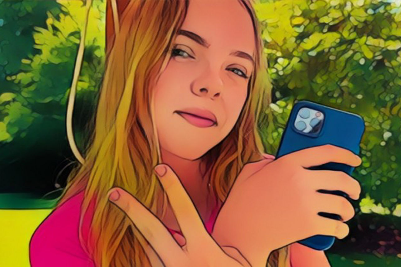 Mädchen hält ihr Handy in der Hand und zeigt mit der anderen Hand das Peace-Zeichen