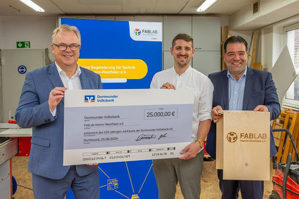 Markus Dünnebacke und Burkhard Reher überreichen Scheck an Nils Reuter