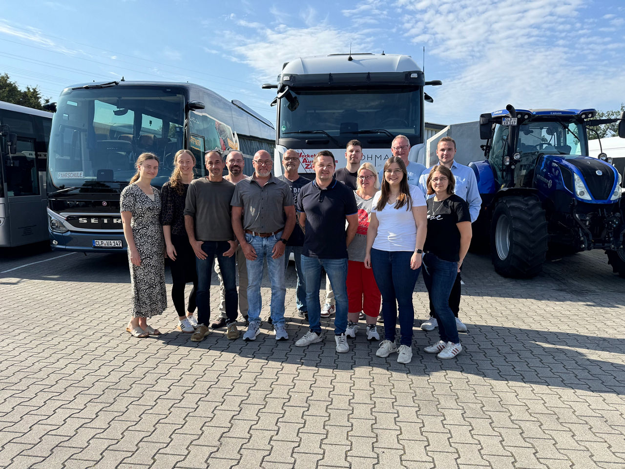 Eine Gruppe von Menschen steht vor einem großen Bus 