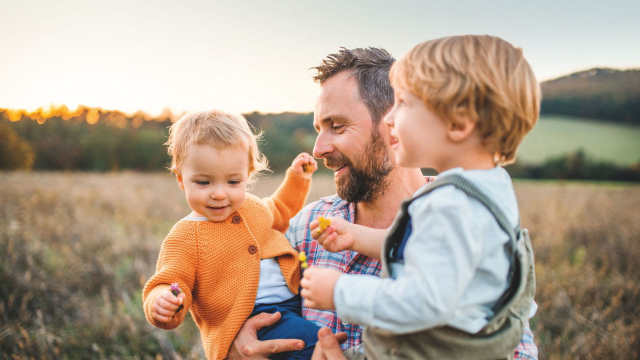 Mann mit zwei Kindern auf den Armen