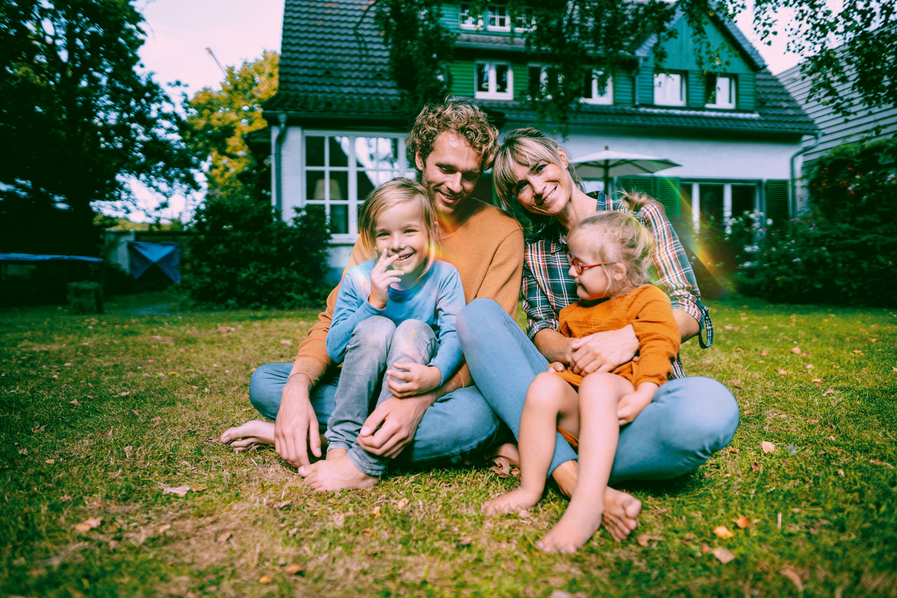 Smiling parents with children in front yard